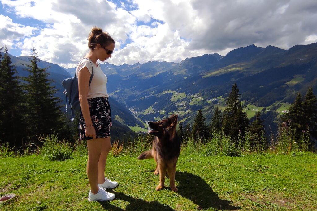 Samen met de hond met uitzicht op de bergen in Oostenrijk